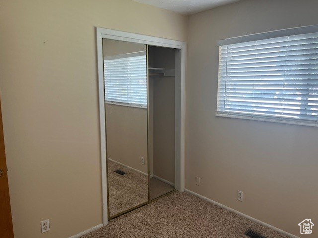 Unfurnished bedroom with carpet flooring and a closet