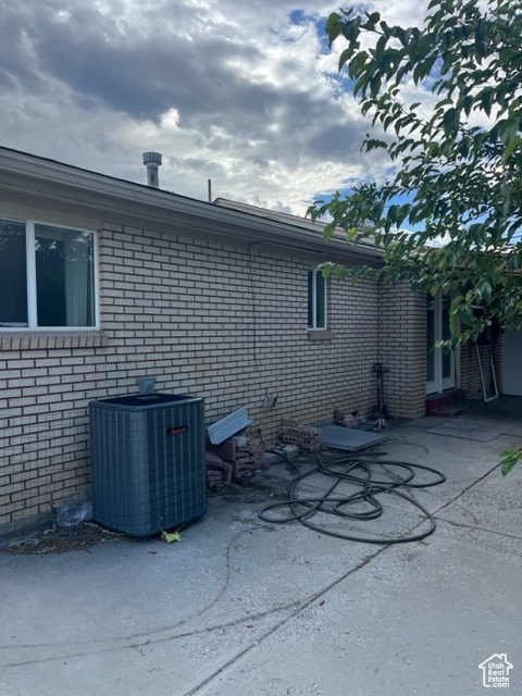 View of side of home with cooling unit and a patio area