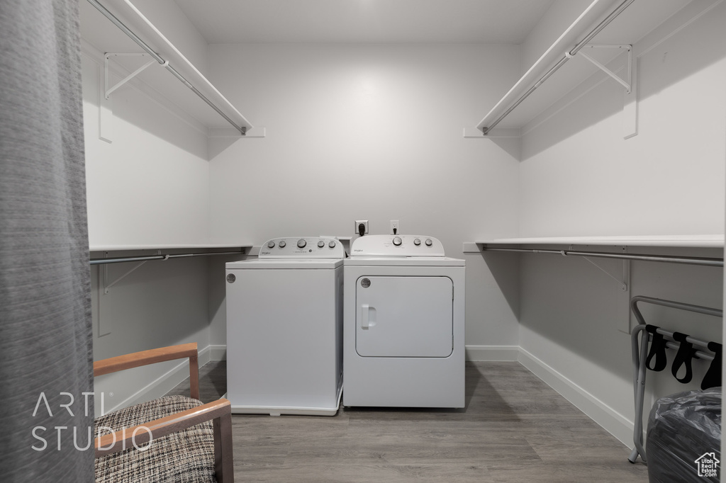 Laundry room featuring washing machine and clothes dryer and wood-type flooring