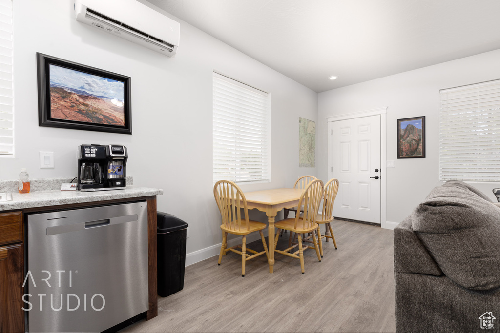 Dining area featuring light hardwood / wood-style floors and a wall mounted air conditioner