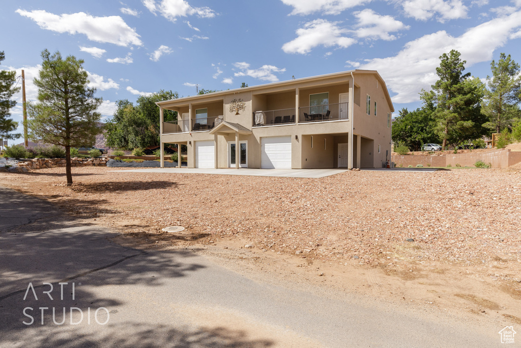 View of front of property with a balcony and a garage