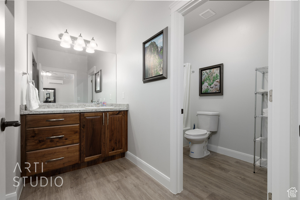 Bathroom with wood-type flooring, toilet, walk in shower, and vanity