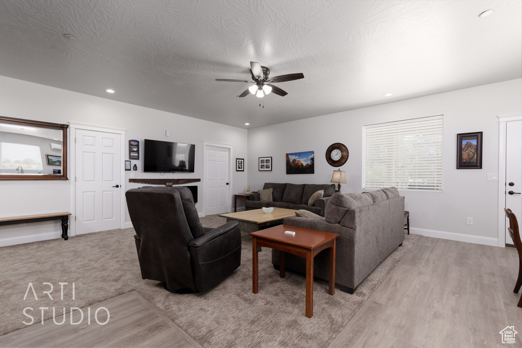 Carpeted living room featuring ceiling fan