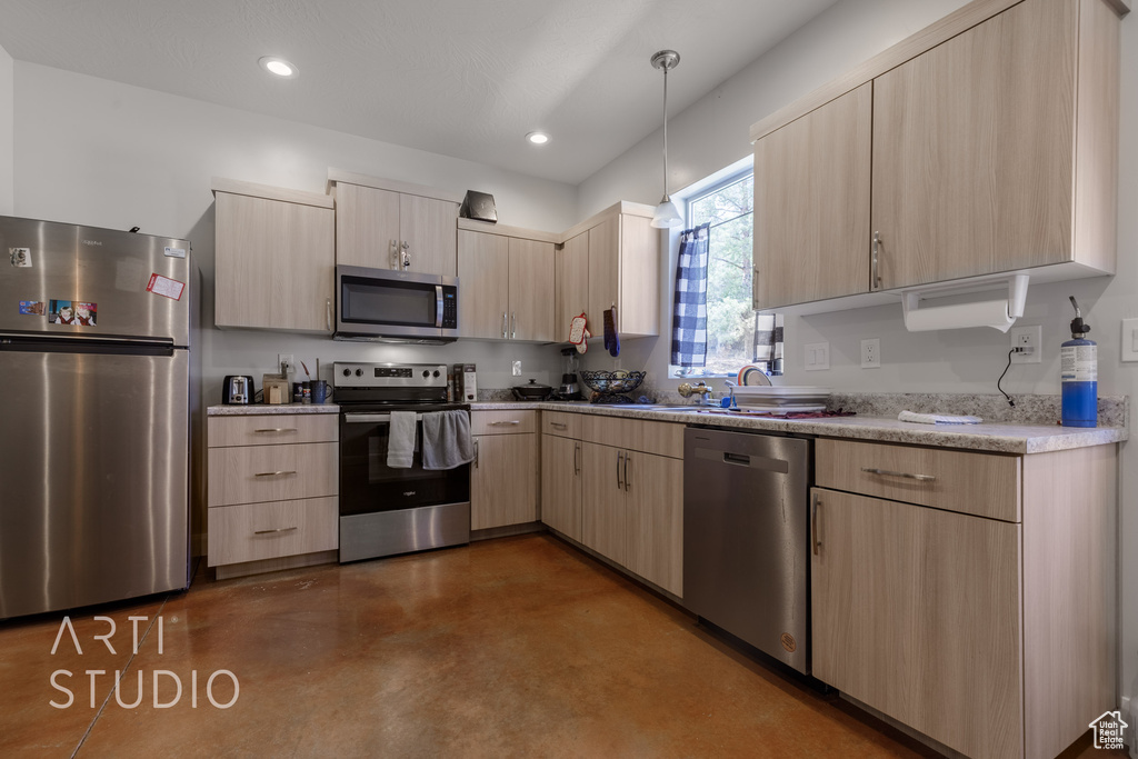 Kitchen with stainless steel appliances, pendant lighting, light brown cabinets, and light stone counters