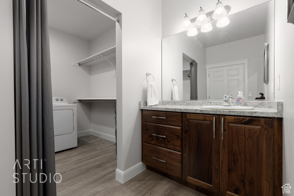 Bathroom featuring vanity, washer / dryer, and wood-type flooring