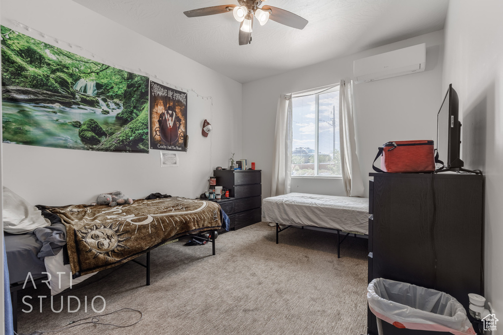 Bedroom with ceiling fan, carpet, and a wall mounted air conditioner