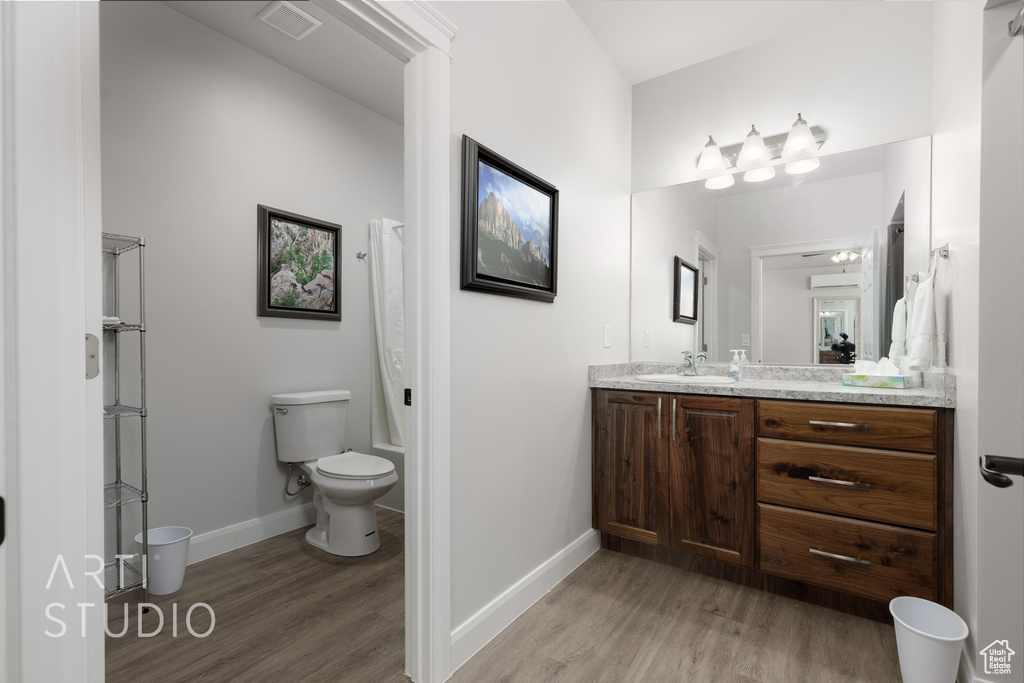 Bathroom featuring vanity, hardwood / wood-style floors, and toilet