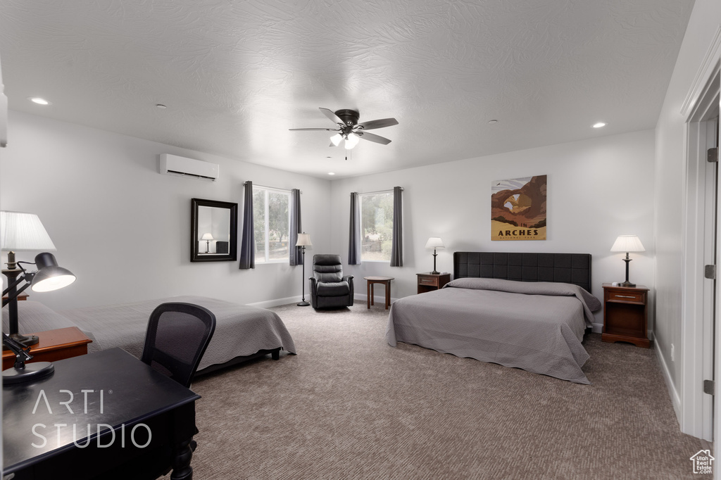 Bedroom with ceiling fan, an AC wall unit, and carpet flooring