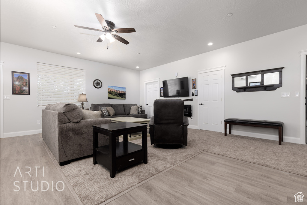 Living room with ceiling fan and light carpet