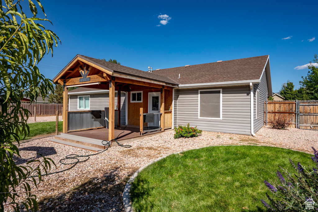 Back of house with a wooden deck, a lawn, and central AC unit