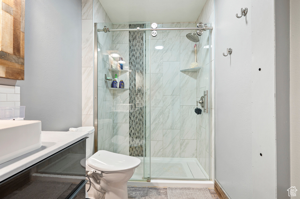 Bathroom featuring walk in shower, toilet, and vanity