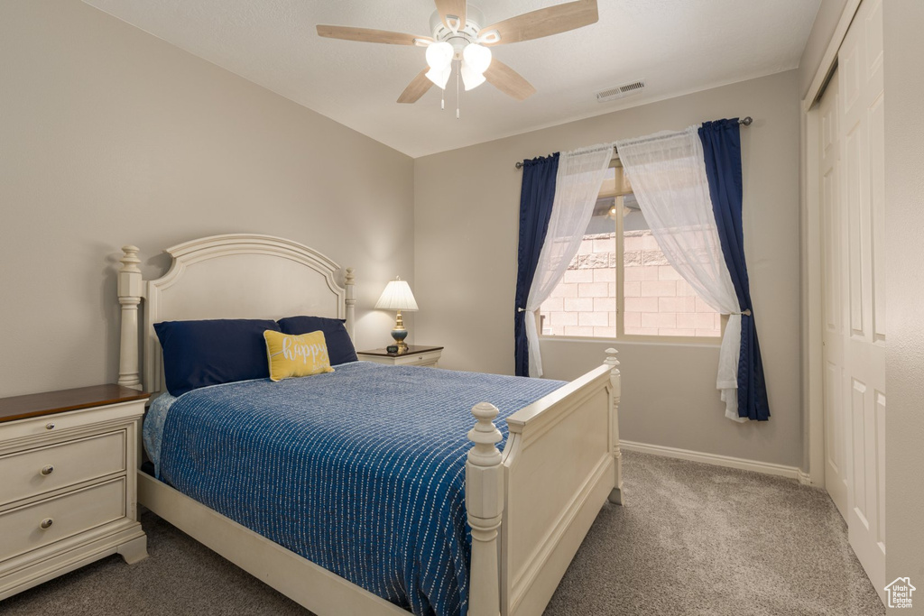 Carpeted bedroom featuring a closet and ceiling fan