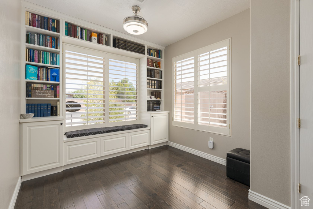 Empty room featuring plenty of natural light and dark hardwood / wood-style flooring