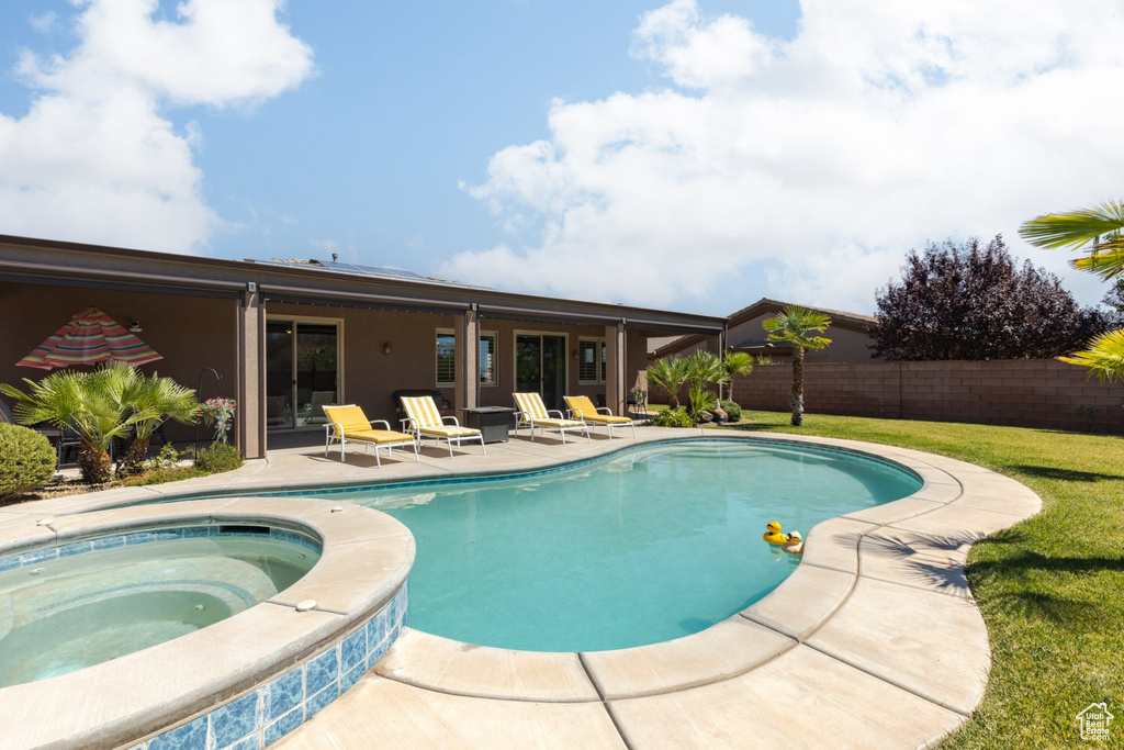 View of swimming pool featuring an in ground hot tub, a lawn, and a patio