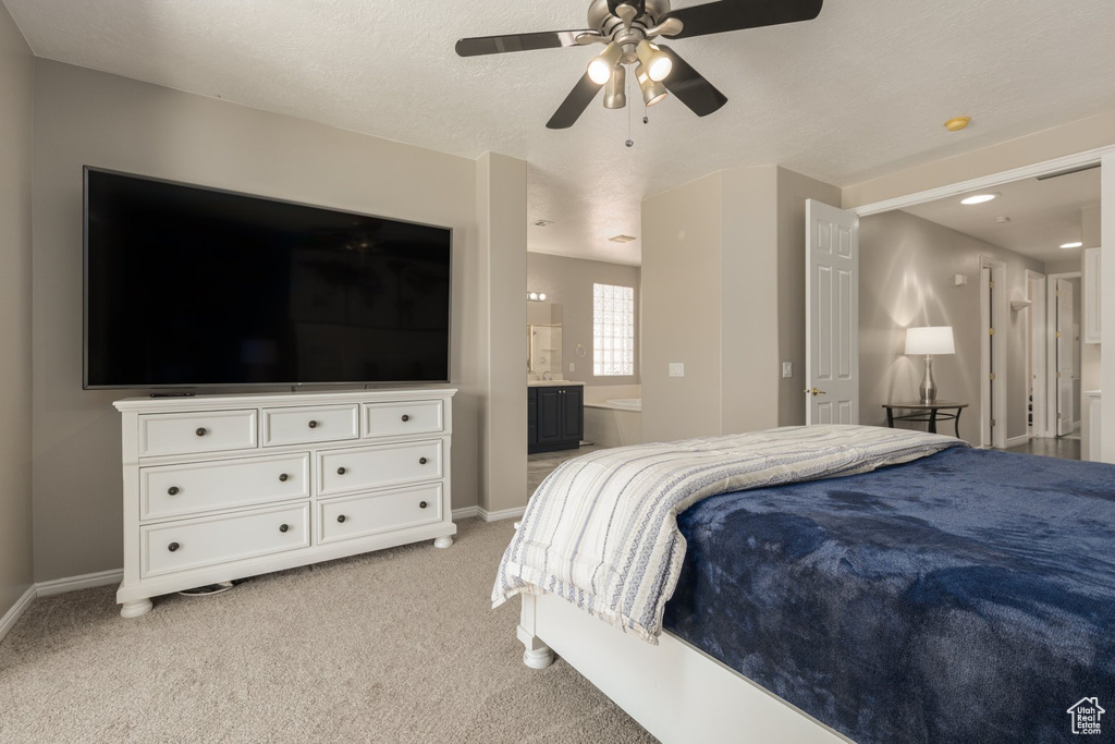 Carpeted bedroom with ceiling fan and connected bathroom