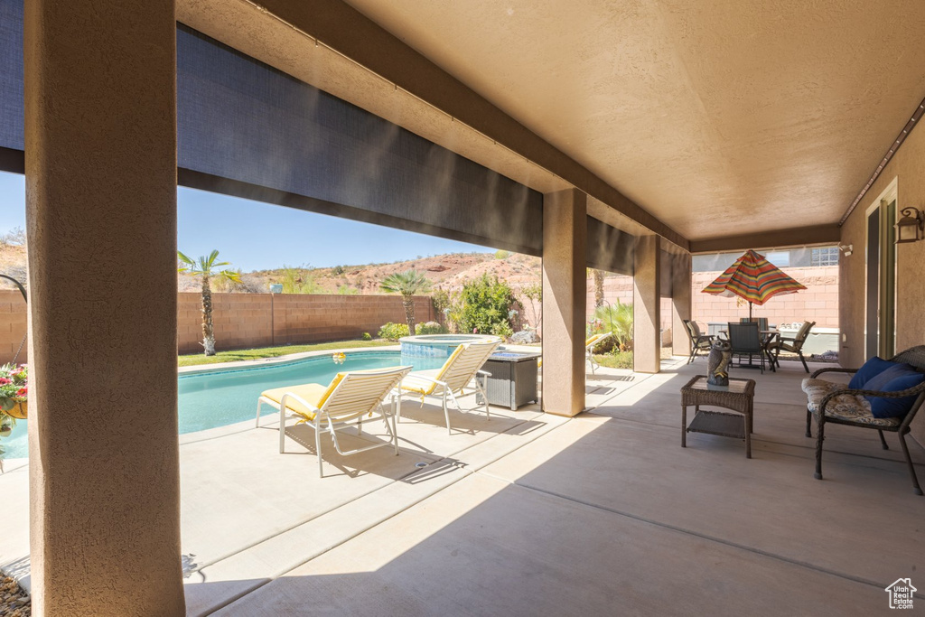 View of patio / terrace with a fenced in pool and a mountain view