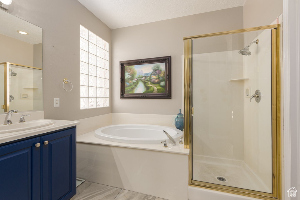 Bathroom featuring vanity, independent shower and bath, and tile patterned flooring