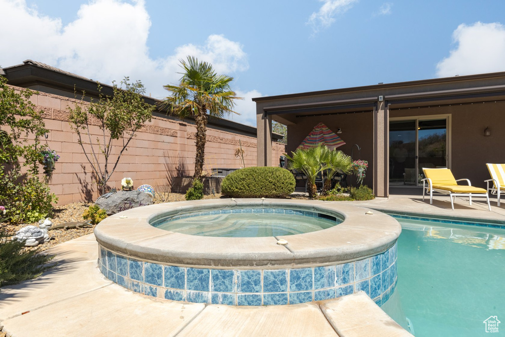 View of swimming pool featuring an in ground hot tub and a patio area