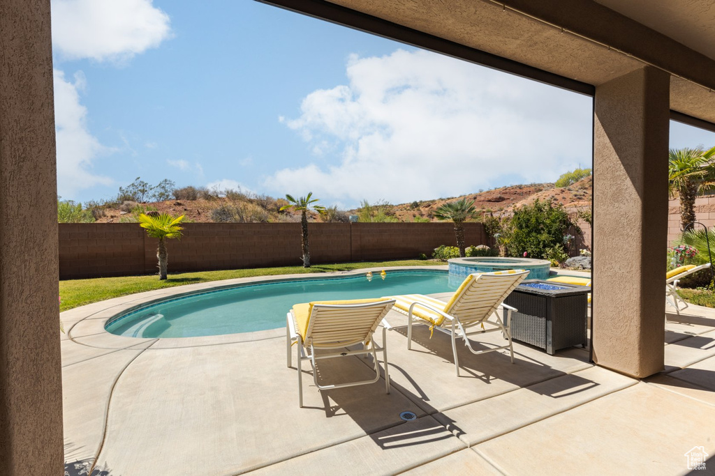 View of swimming pool featuring a patio and an in ground hot tub