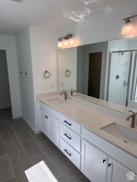 Bathroom featuring vanity, an enclosed shower, and tile patterned floors