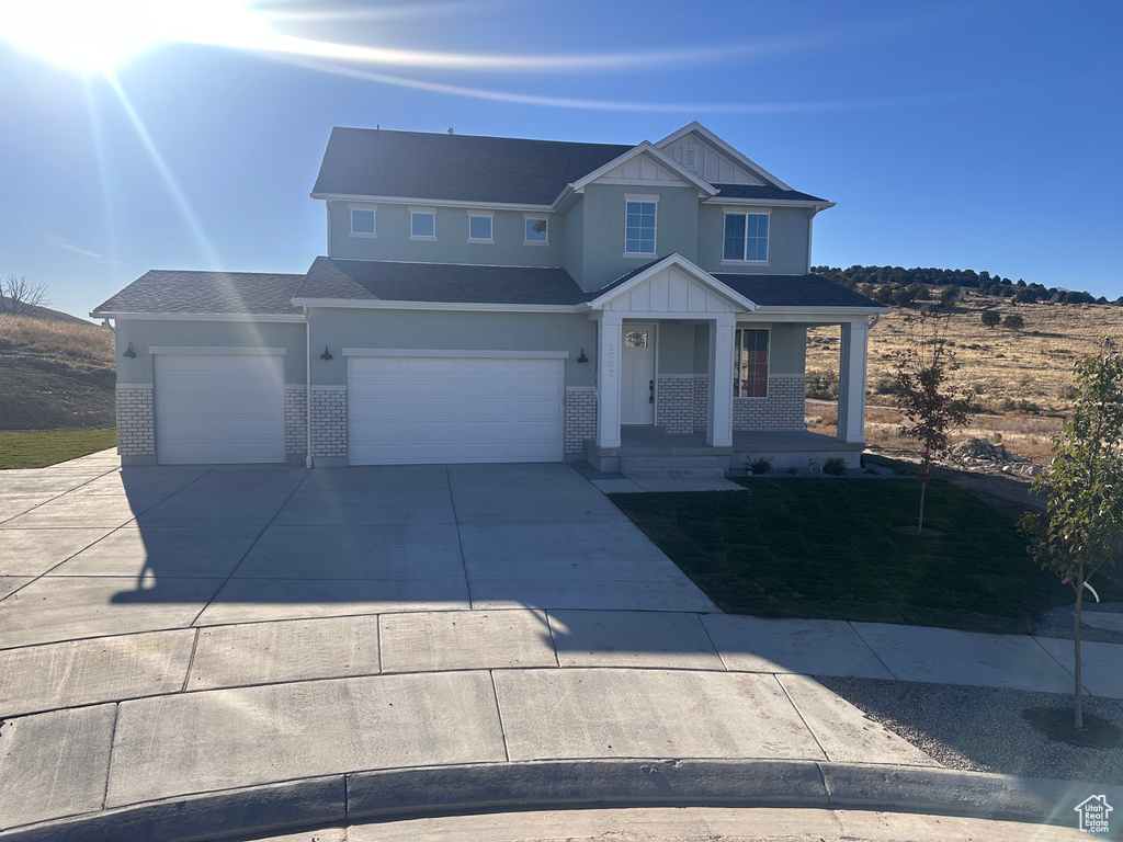 View of front of property with covered porch and a garage