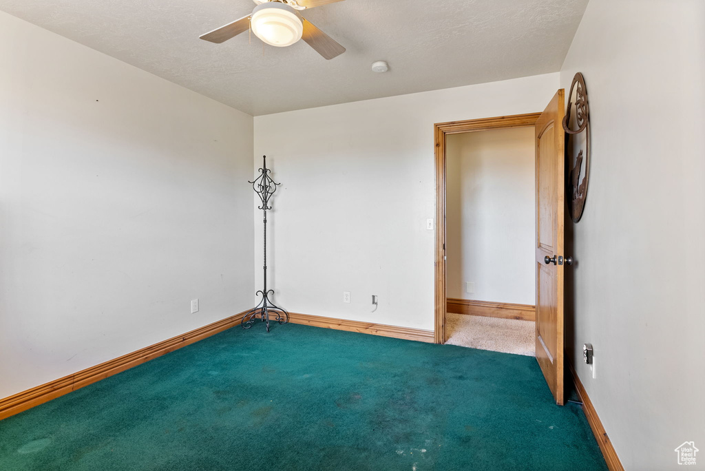 Spare room featuring carpet flooring and ceiling fan