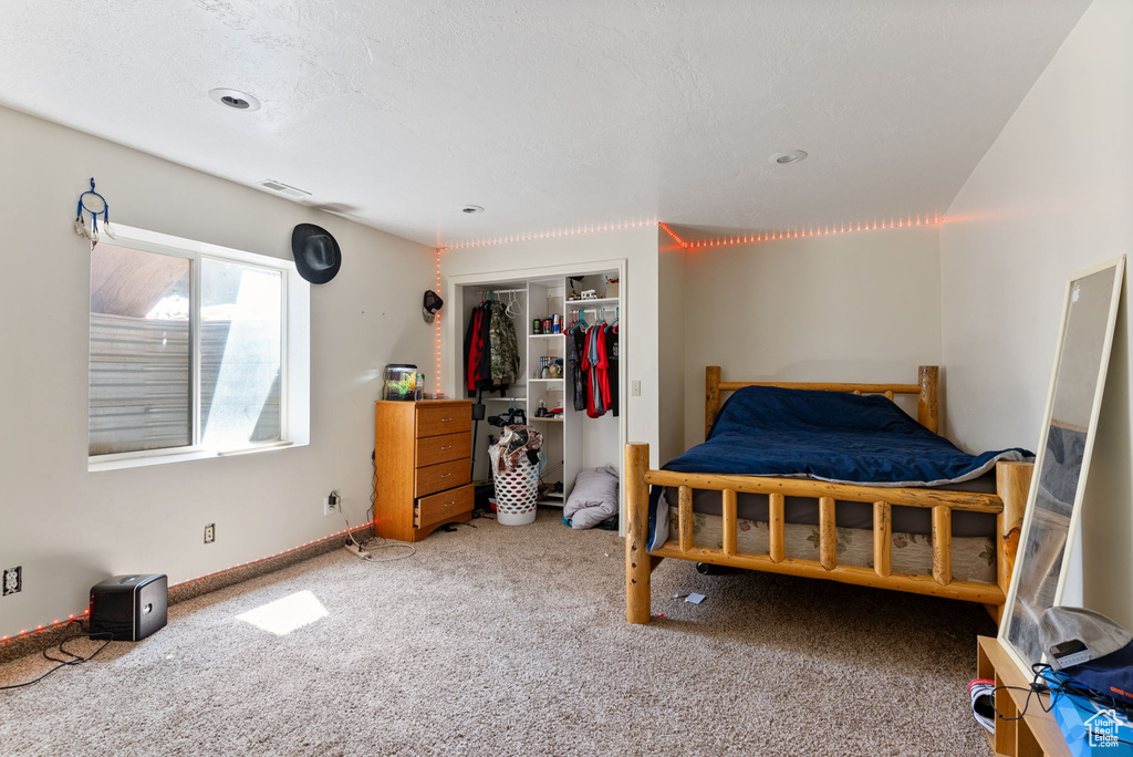 Bedroom with a closet, carpet, and a textured ceiling