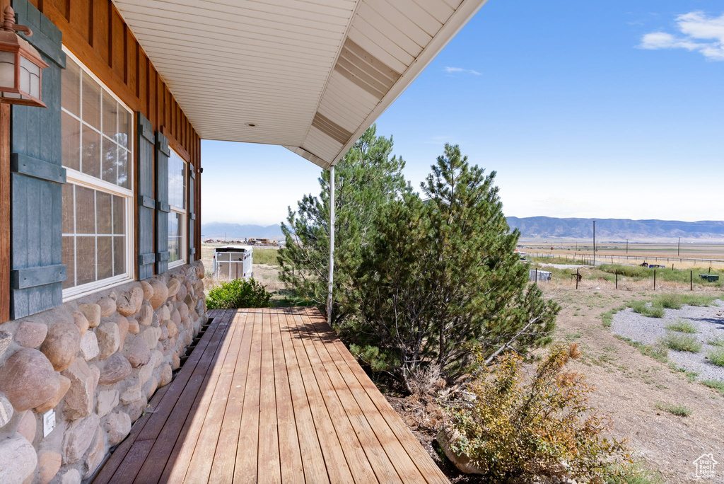 Wooden deck featuring a rural view and a mountain view