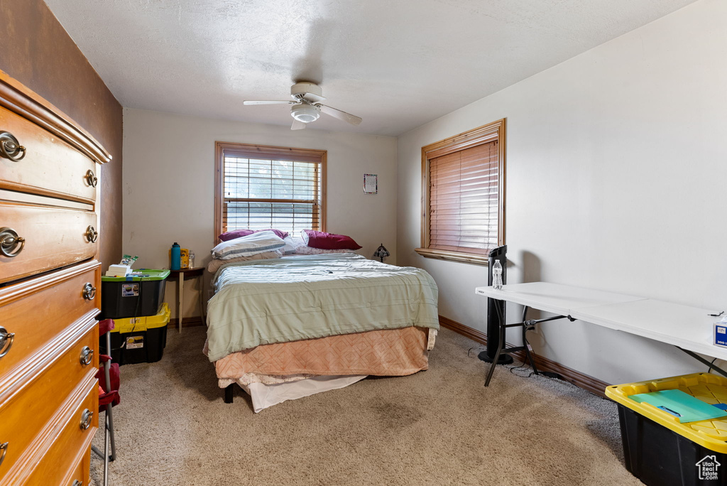 Carpeted bedroom featuring ceiling fan