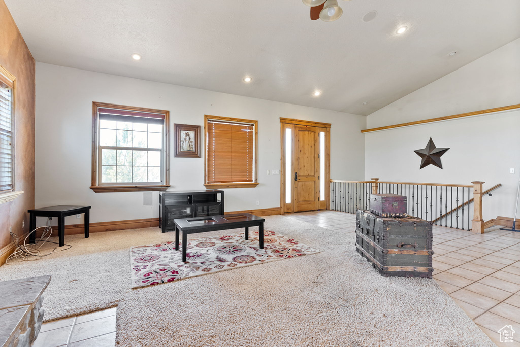 Carpeted living room with vaulted ceiling and ceiling fan