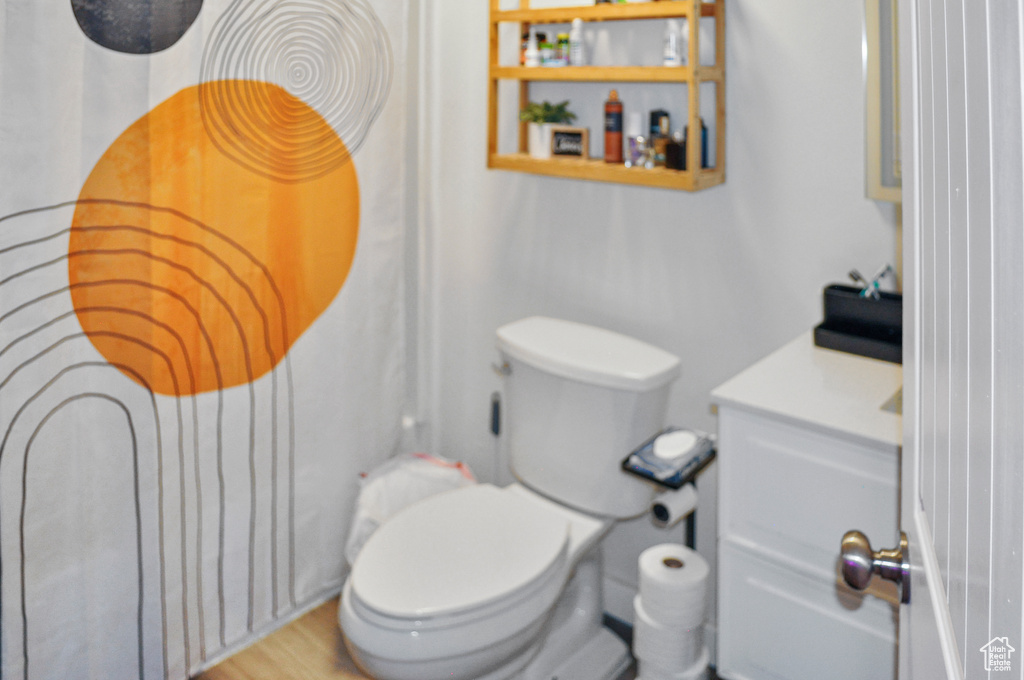 Bathroom with vanity, toilet, and hardwood / wood-style flooring