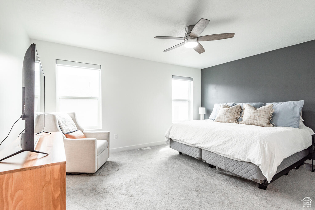 Carpeted bedroom featuring ceiling fan