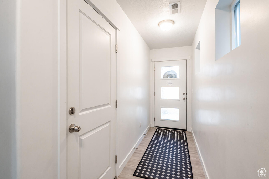 Doorway with light hardwood / wood-style flooring