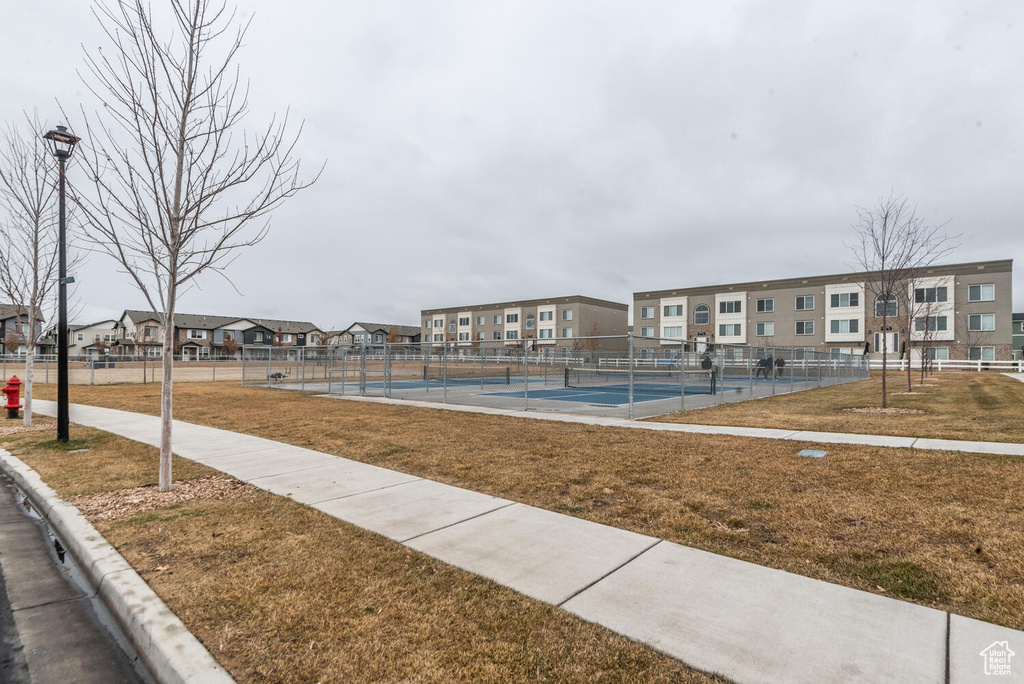 View of property's community featuring a lawn and tennis court