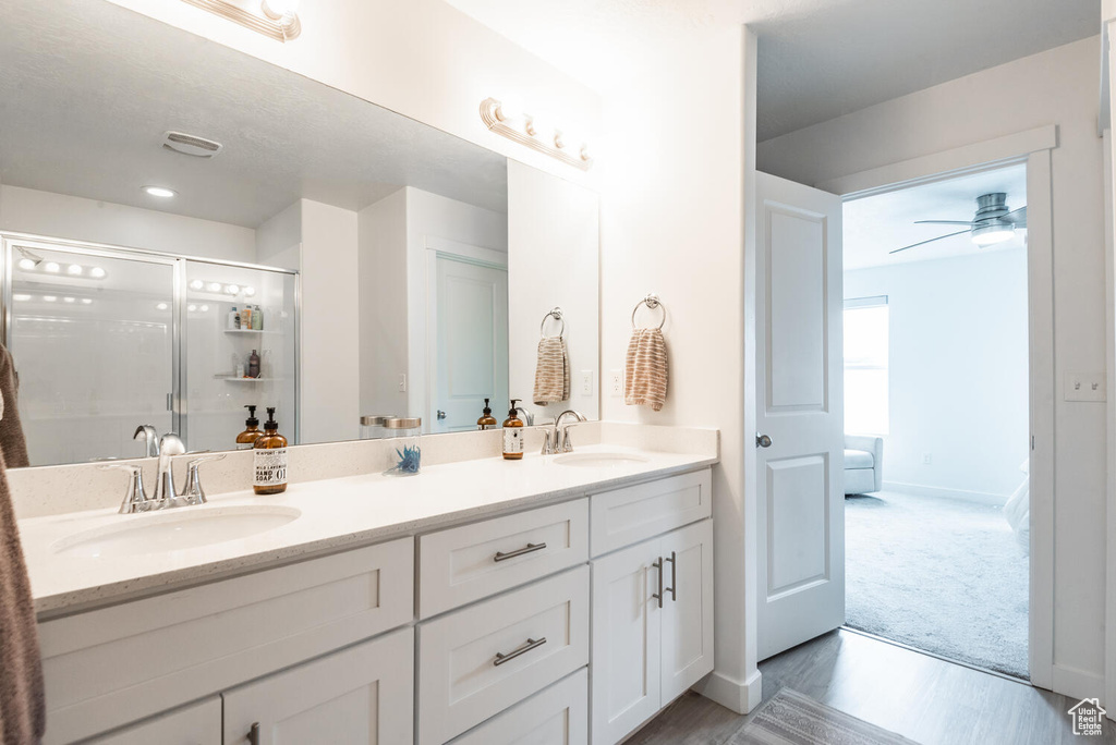 Bathroom featuring vanity, ceiling fan, wood-type flooring, and a shower with shower door