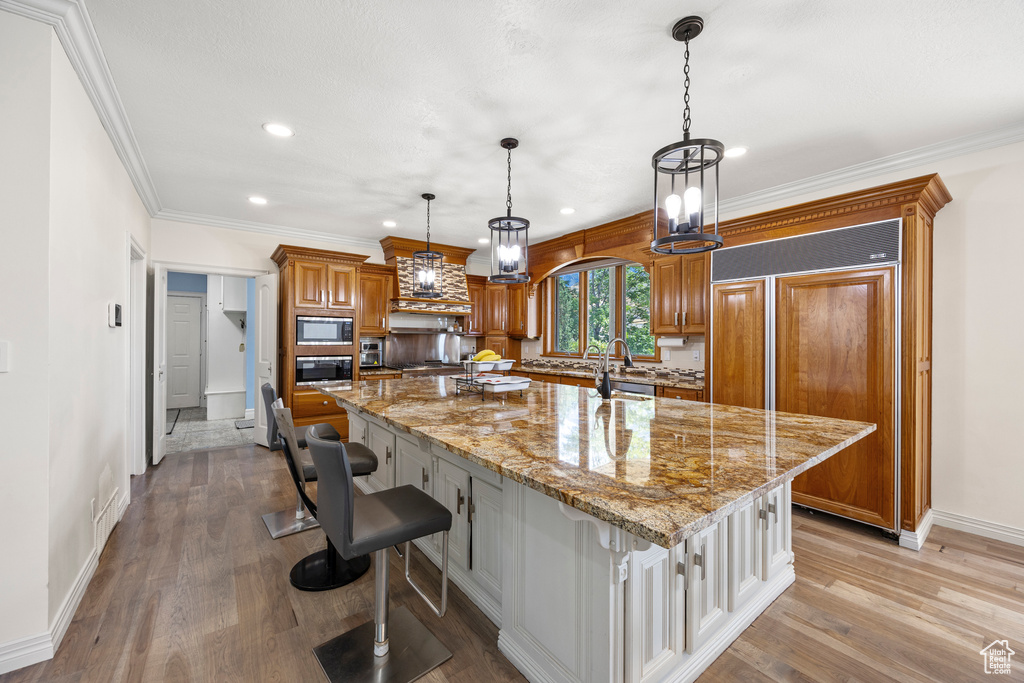 Kitchen with light wood-type flooring, a kitchen breakfast bar, and a large island