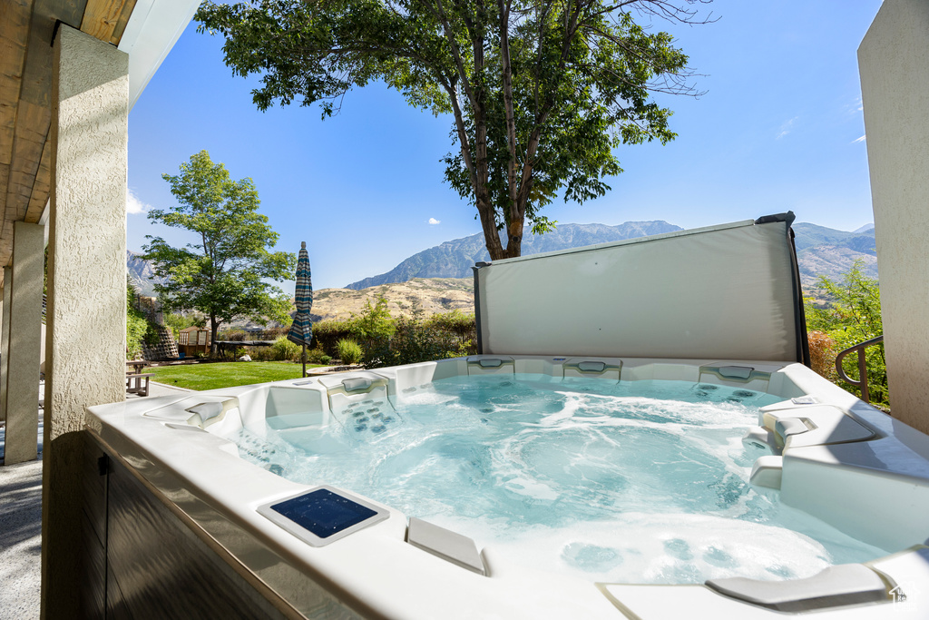 View of swimming pool featuring a mountain view and a hot tub