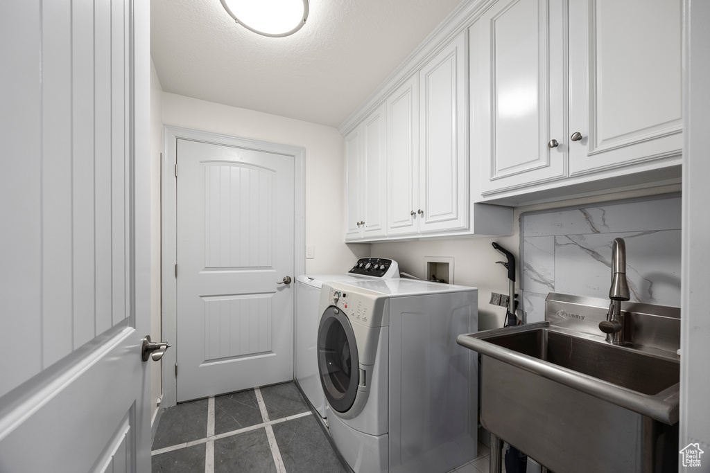 Laundry room with cabinets, sink, tile patterned floors, and washing machine and dryer