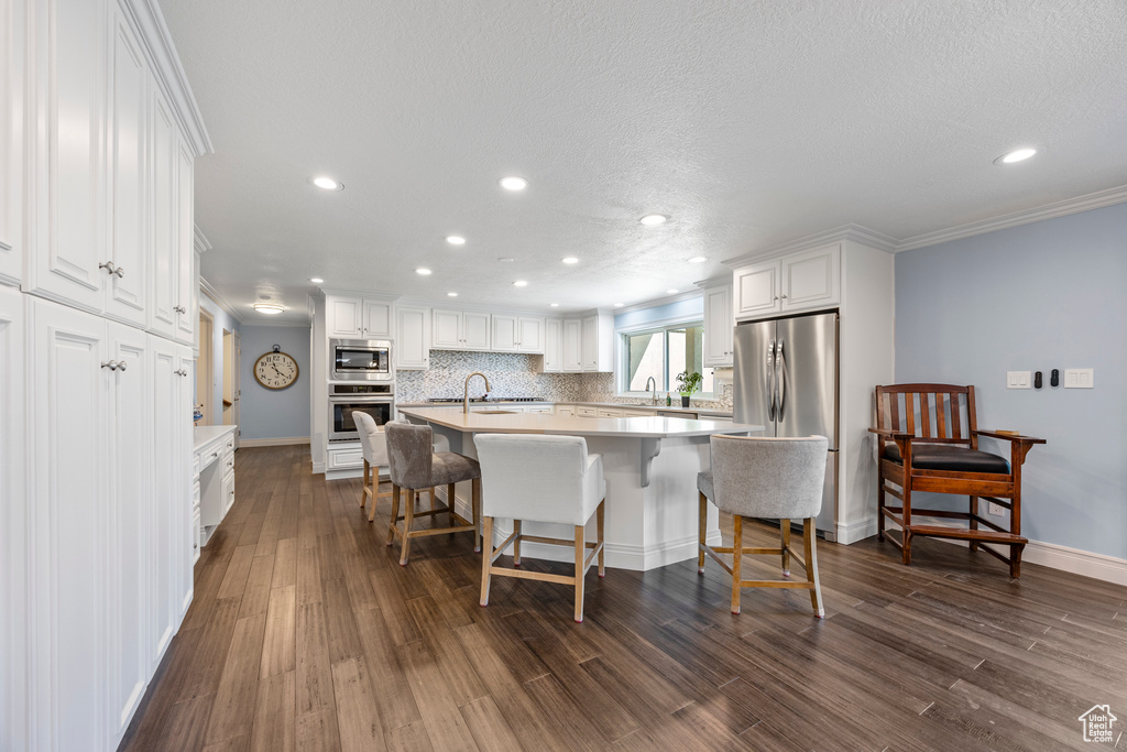 Kitchen featuring white cabinets, appliances with stainless steel finishes, and dark hardwood / wood-style floors