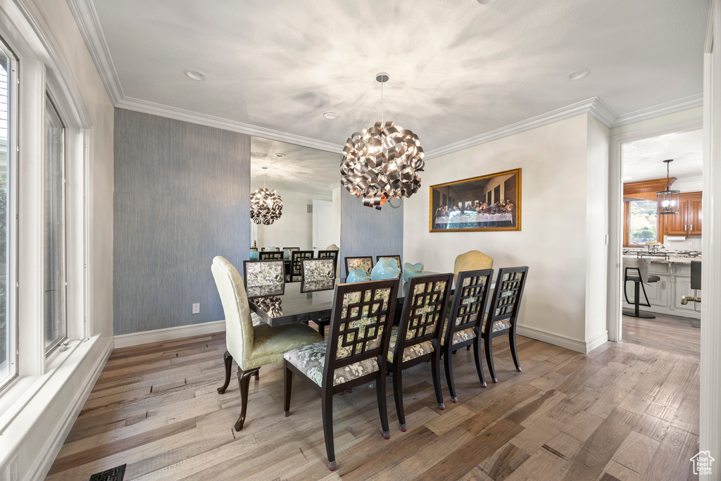 Dining room featuring ornamental molding, a chandelier, and hardwood / wood-style flooring