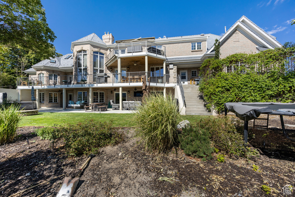 Rear view of property featuring a balcony and a patio area