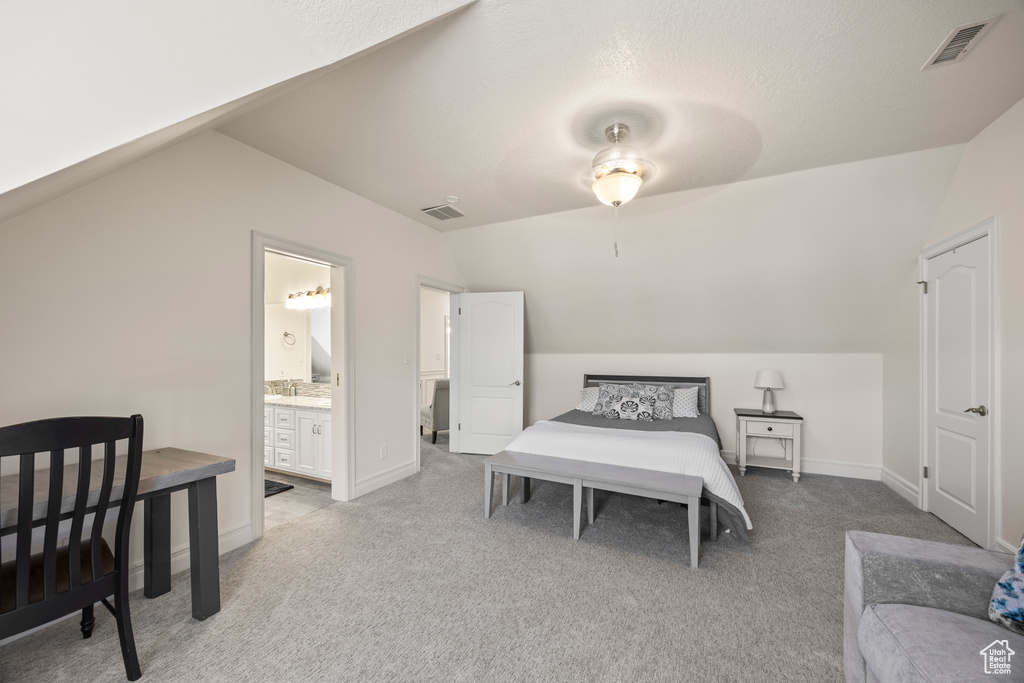 Bedroom featuring lofted ceiling, ceiling fan, light colored carpet, and ensuite bathroom