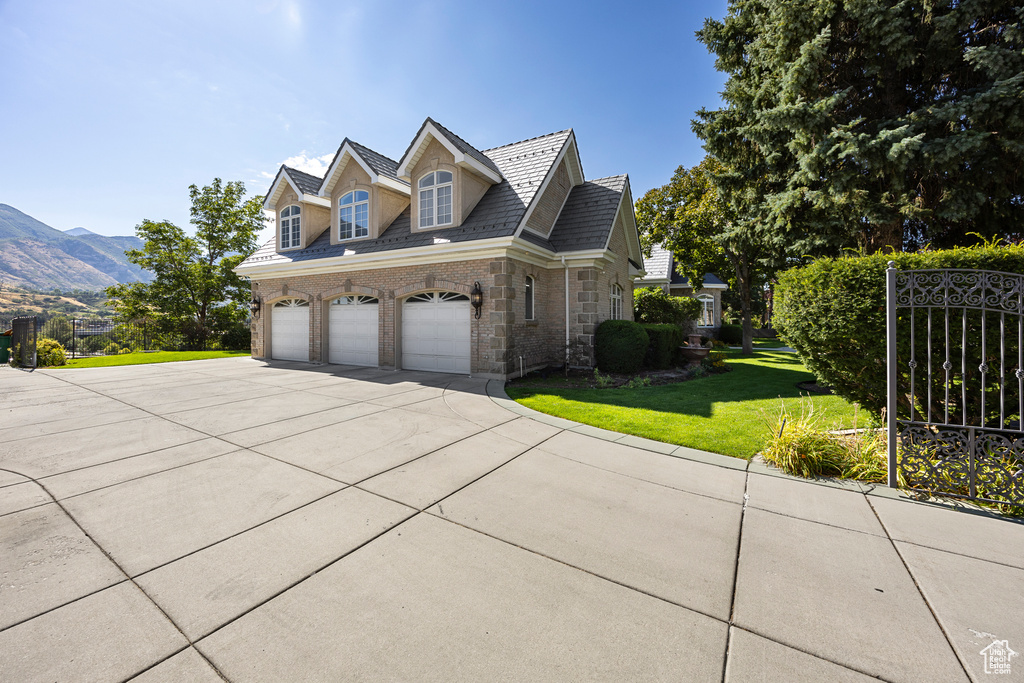 View of home's exterior with a mountain view, a yard, and a garage