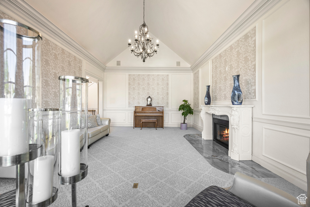 Interior space featuring an inviting chandelier, crown molding, vaulted ceiling, light colored carpet, and a premium fireplace