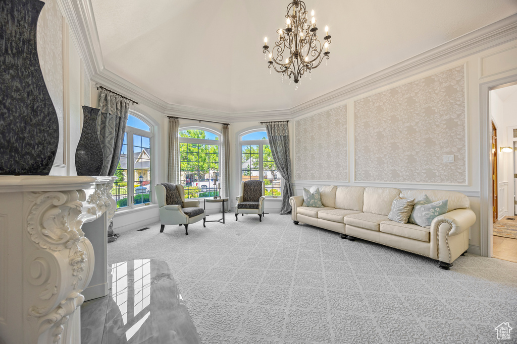 Carpeted living room with crown molding and a notable chandelier