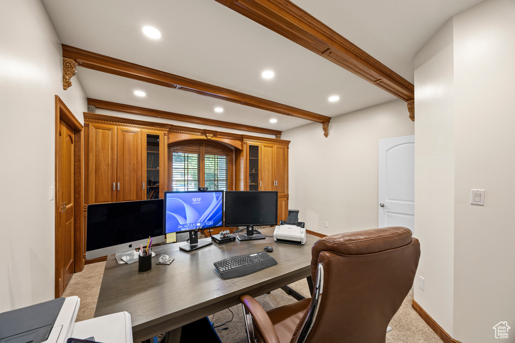 Carpeted office space featuring beam ceiling