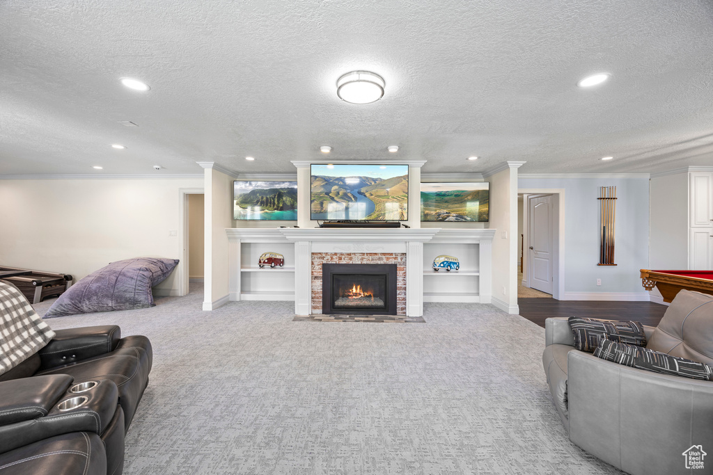 Carpeted living room with built in features, billiards, crown molding, and a textured ceiling