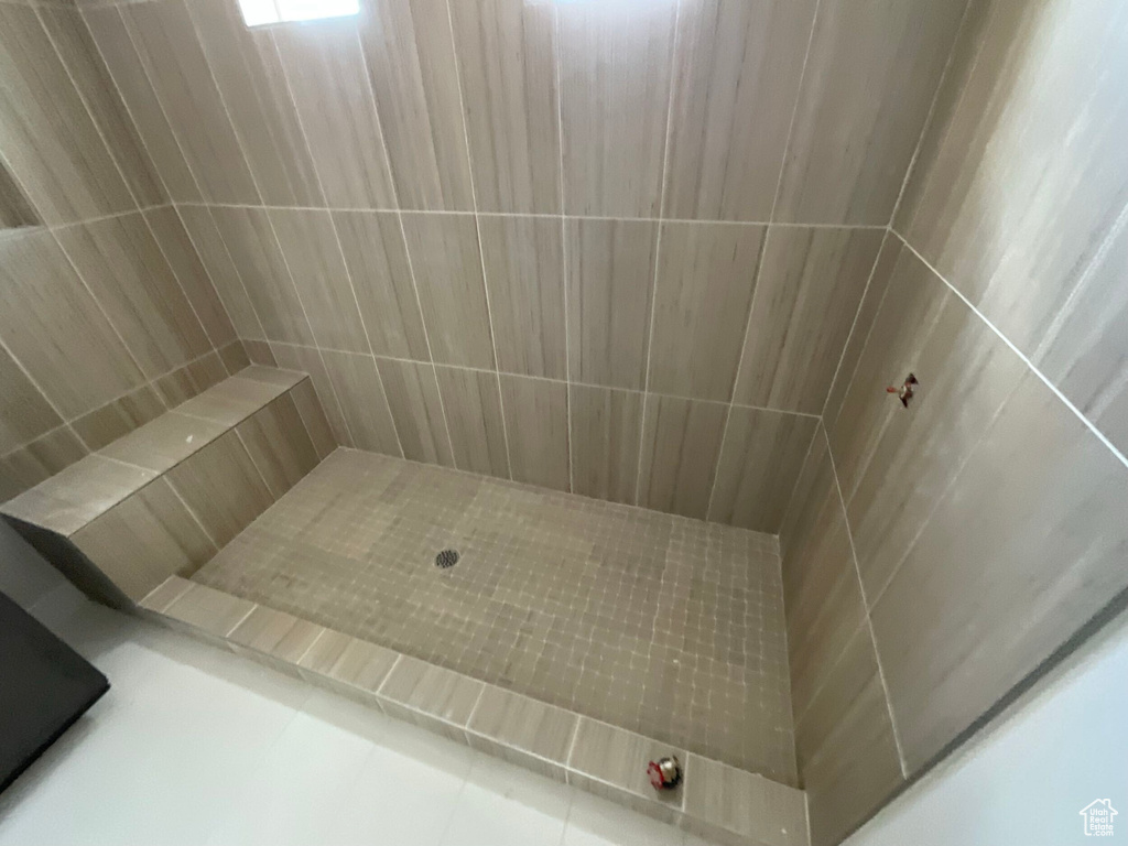 Bathroom featuring tiled shower and tile patterned floors