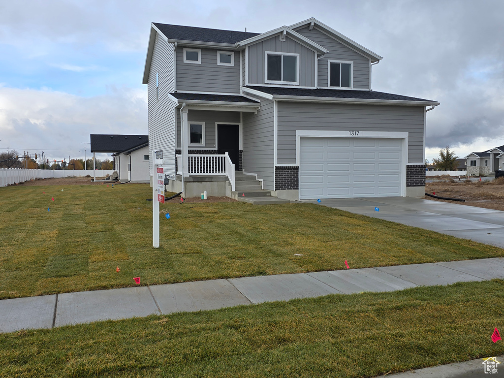 View of front of house featuring a garage and a front lawn