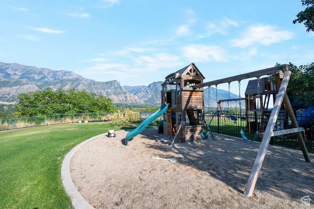 View of jungle gym featuring a lawn and a mountain view